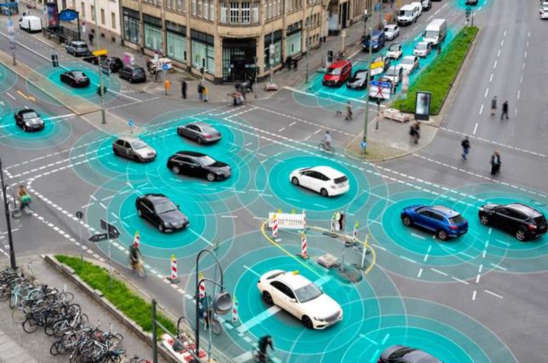 Autos fahren über eine Kreuzung. Sie geben blaue Energie ab.