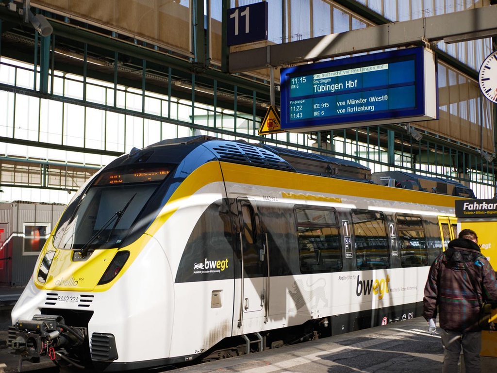 Ein bwegt-Zug im weiß-gelb-schwarzen Landesdesign steht im Hauptbahnhof von Stuttgart am Gleis.