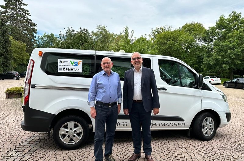 Landesverkehrsminister Winfried Hermann (l.) und Landrat Dr. Rückert (Freudenstadt) stehen vor einem weißen Kleinbus.