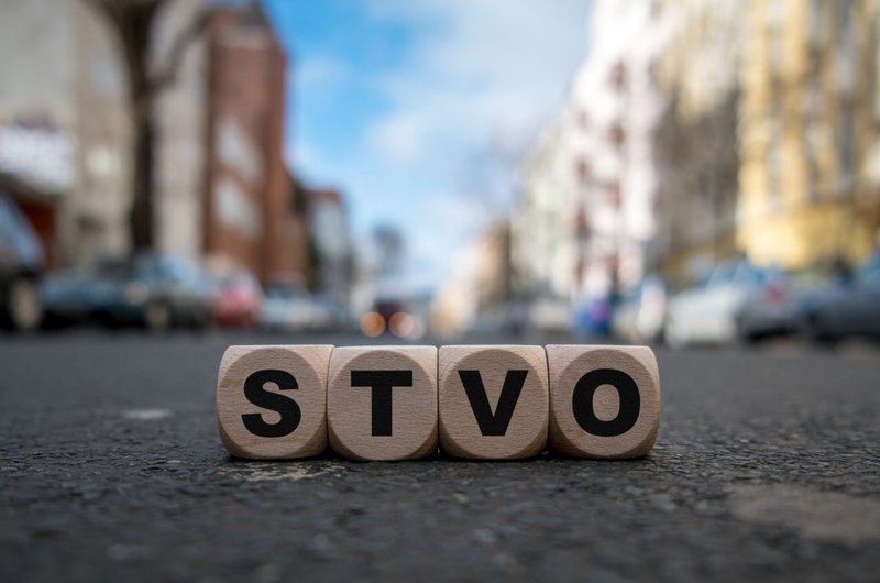 Würfel mit den Buchstaben StVO liegen auf einer Straße.