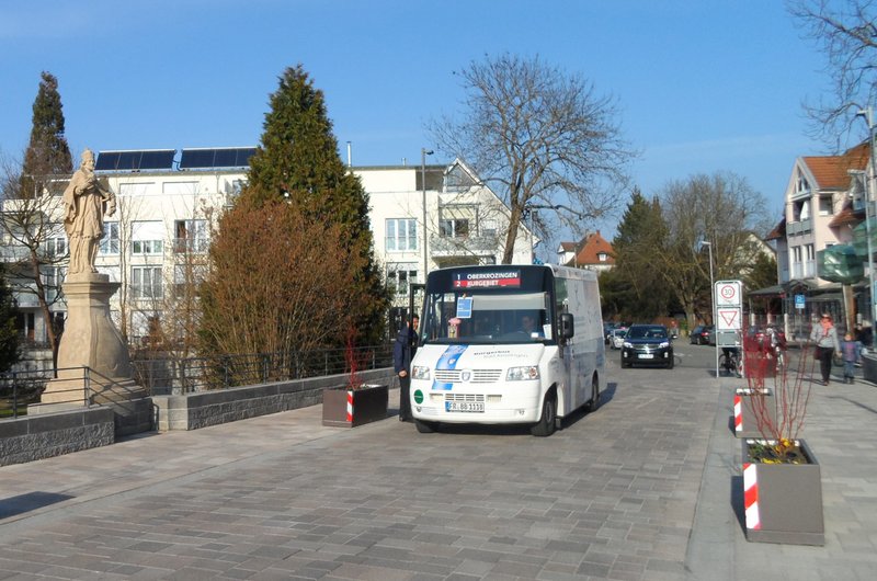 Der blau-weiße Bürgerbus von Bad Krozingen steht mit offener Tür an der Straße und ein Mann steigt ein.