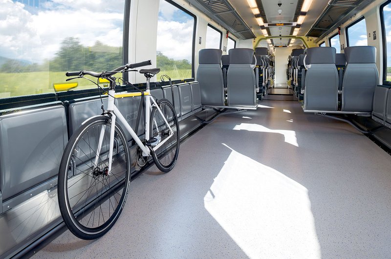 Ein weißes Fahrrad steht im Innenbereich eines Regionalzuges.