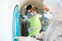 Jugendliche mit Schutzanzügen und Atemmasken sprühen Graffiti an eine Wand in einem Tunnel